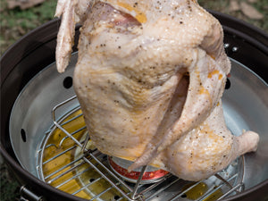 Place the chicken upright over the Beer Can Chicken Roaster.
